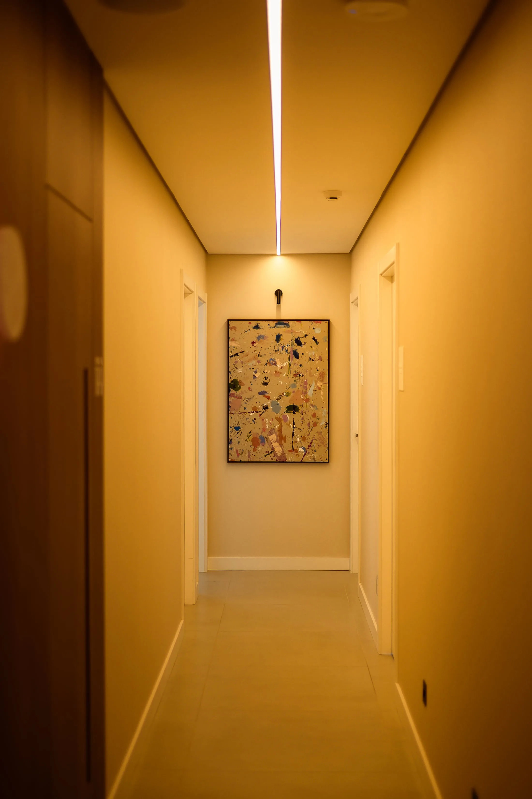 Corredor da Ocker Medicina Integrada com luz linear no teto e um quadro ao fundo