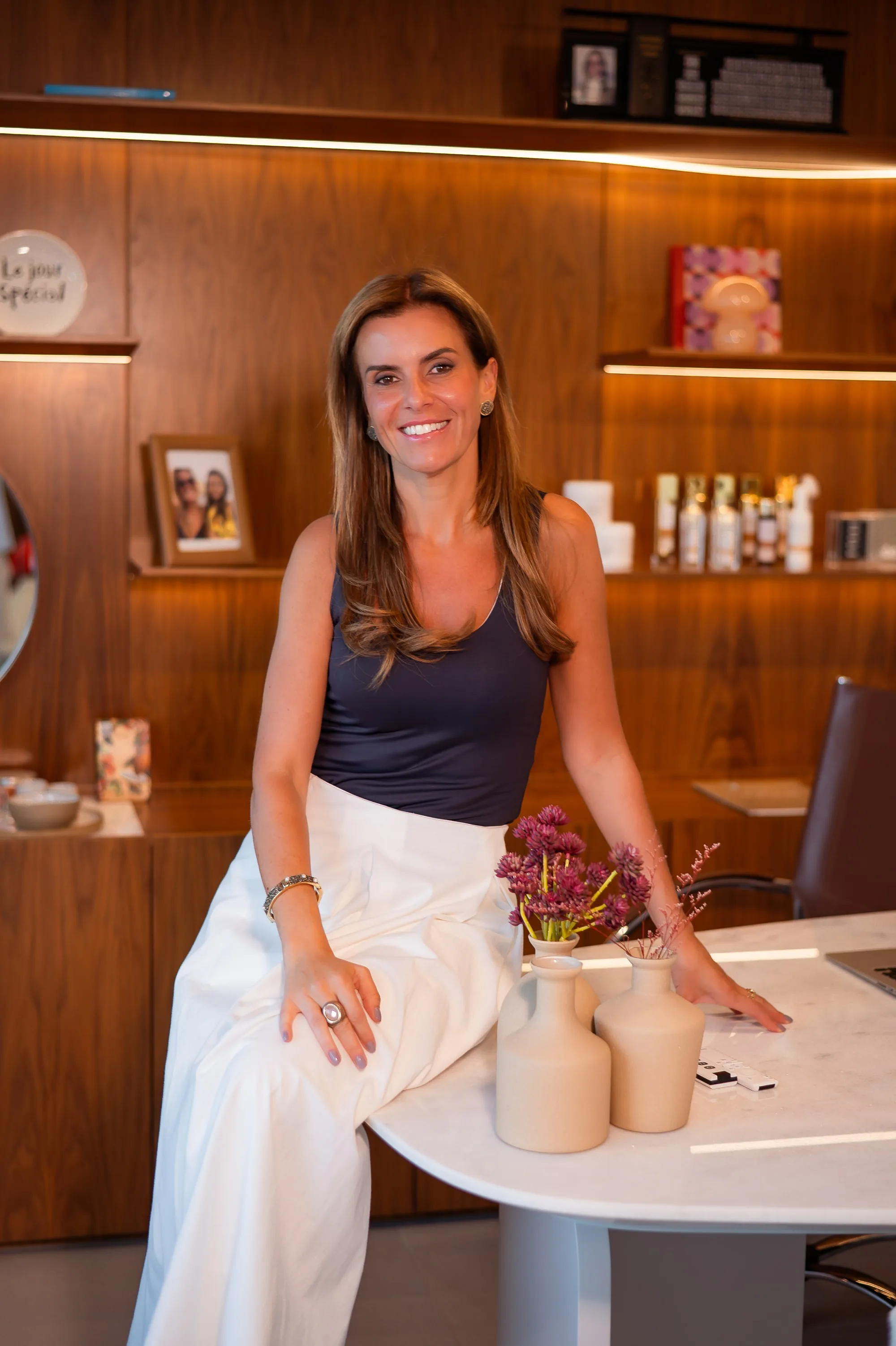 Dra. Juliana Ocker diante das prateleiras do consultório da Ocker Medicina Integrada, em Mafra